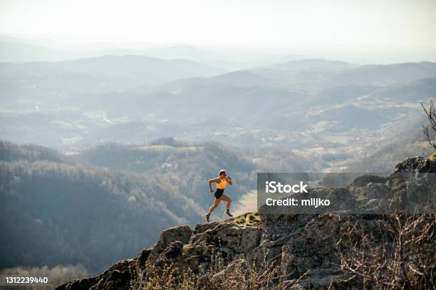 Frau Läuft Auf Berg Stockfoto und mehr Bilder von Rennen - Körperliche Aktivität - Rennen - Körperliche Aktivität, Sport, Natur