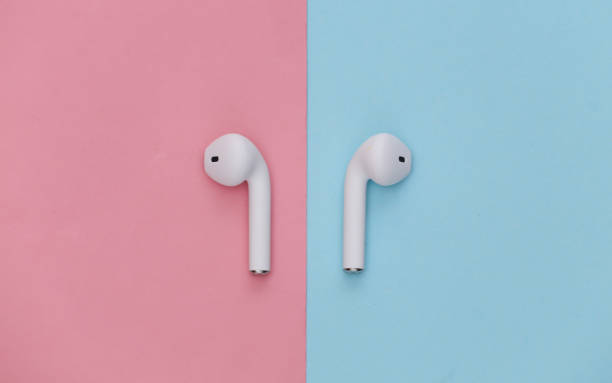 istock Modern wireless earphones on pink blue pastel background. Top view. Flat lay 1312240370