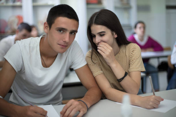 istock Teenagers students sitting in the classroom working exam. Focus is on foreground. 1312241350