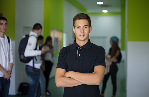 Portrait of male student.  Male Students standing in school hallway.