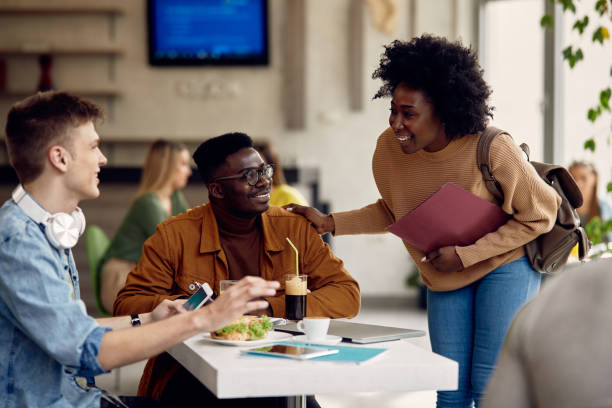 istock Multi-ethnic group of college friends talking on break in cafeteria. 1312241523