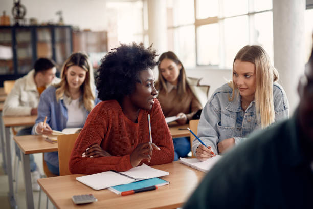 istock Female college students talking during a class in the classroom. 1312241560
