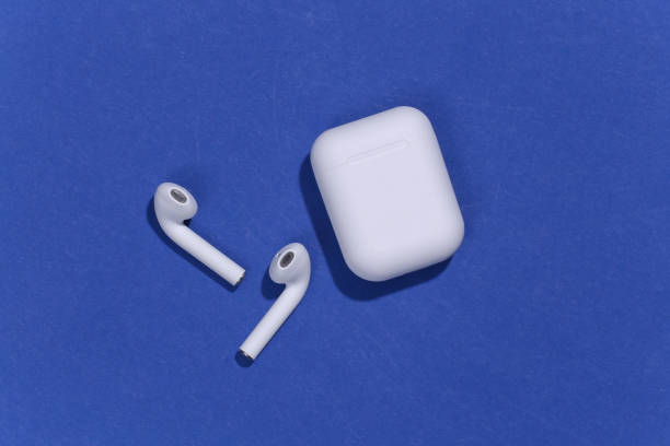 istock White true wireless bluetooth headphones or earbuds with charging case on blue background. Top view. Flat lay 1312241879