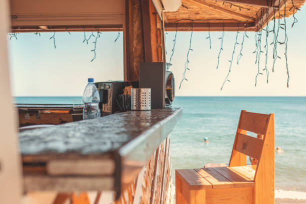 Sunny. An empty bar counter and an empty chair against the background of the beach and the sea. Vacation and summer Sunny. An empty bar counter and an empty chair against the background of the beach and the sea. Vacation and summer. beach bar stock pictures, royalty-free photos & images