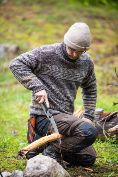 istock A bushcraft man sawing wood outdoors at camp 1312245183