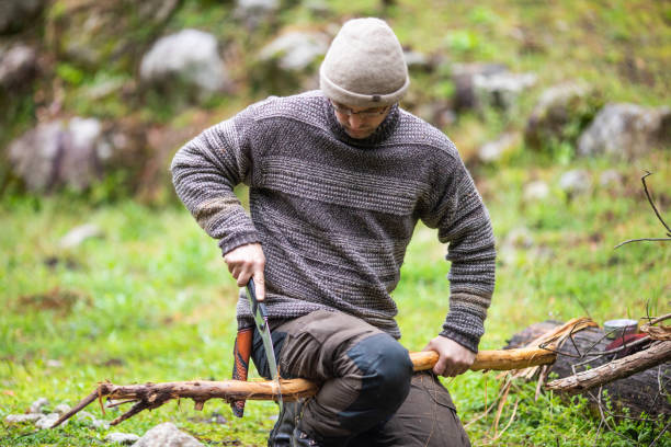 istock A bushcraft man sawing wood outdoors at camp 1312245435