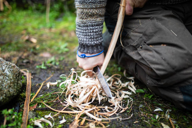 Bushcraft survival man preparing wood tinder for a fire