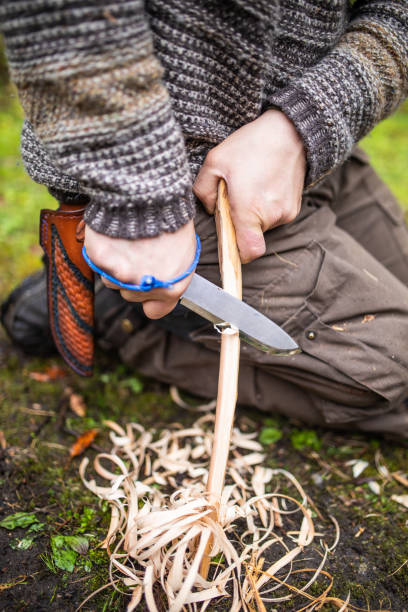 istock Bushcraft survival man preparing wood tinder for a fire 1312245500