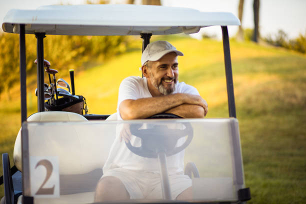 istock Senior man in golf car. 1312248428