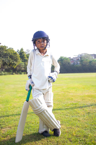istock Boy in cricket uniform holding a cricket bat 1312248788