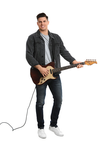 Excited hispanic man smiling while playing the electric guitar against a background with white smoke
