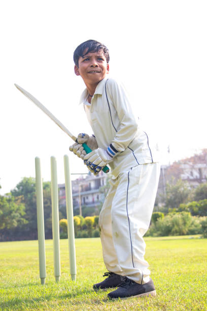istock Young boy batting in protective gear during a cricket 1312248840