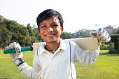 istock Boy in cricket uniform holding a cricket bat 1312248901