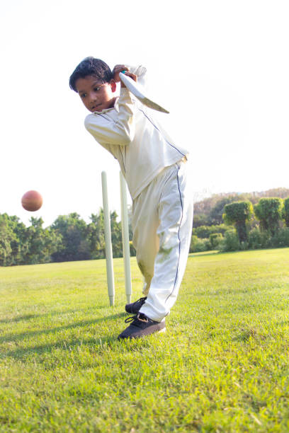 istock Young boy batting in protective gear during a cricket 1312249048