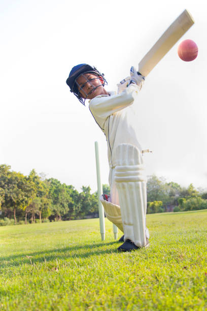 istock Young boy batting in protective gear during a cricket 1312249075