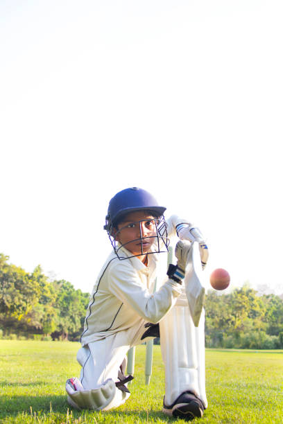 istock Young boy batting in protective gear during a cricket 1312249082