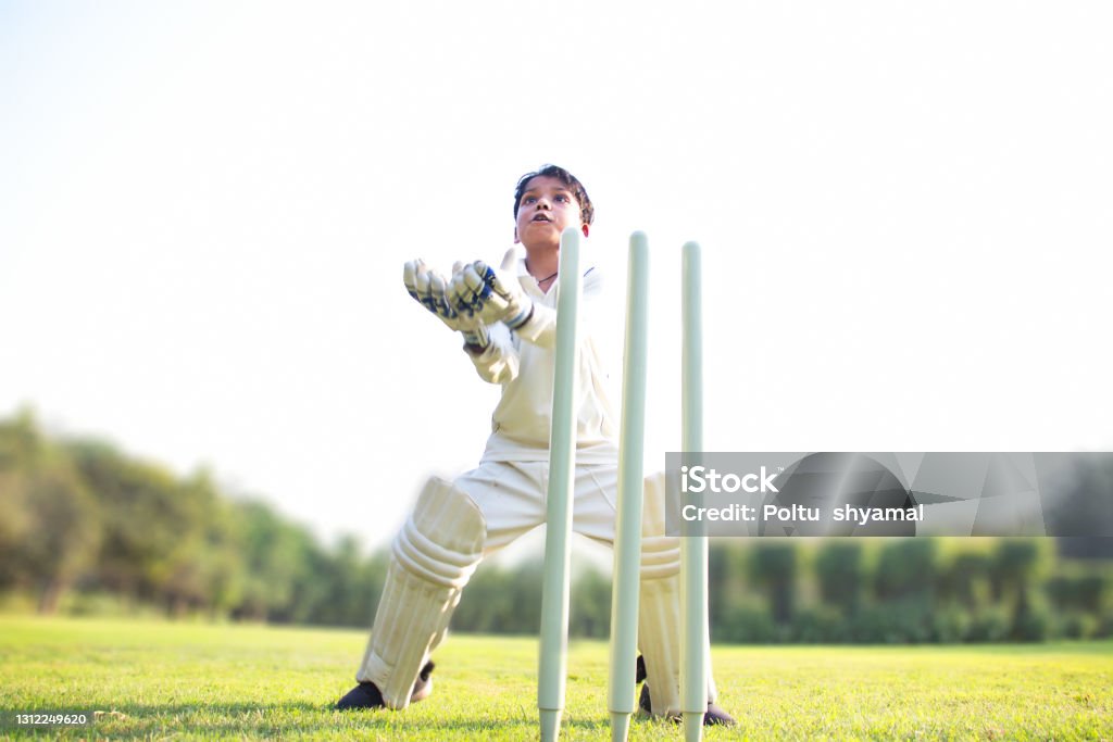 a boy wicket keeper during cricket game Child Stock Photo