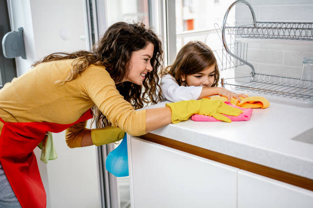 istock Mother and daughter cleaning kitchen counter 1312250018