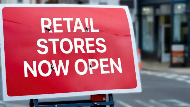 Retail stores now open sign in a city-centre