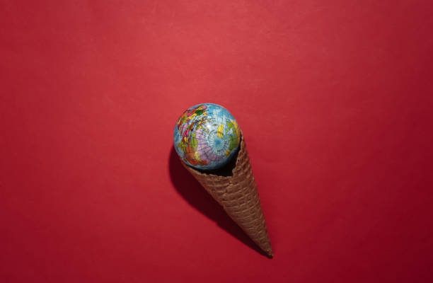 istock Ice cream waffle cone with globe on red bright background. Top view 1312251394