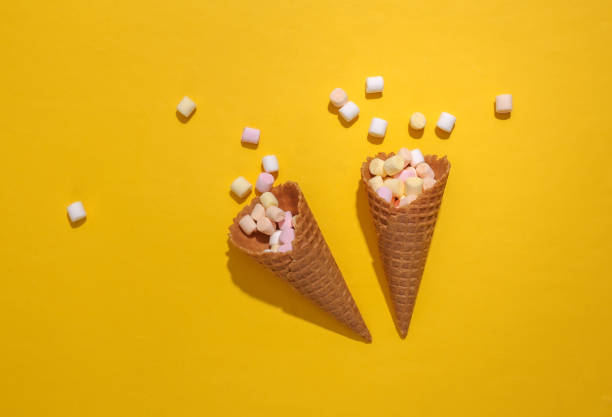 istock Ice cream waffle cones with marshmallows on yellow background with deep shadow, Top view, Flat lay, Pop art 1312251929