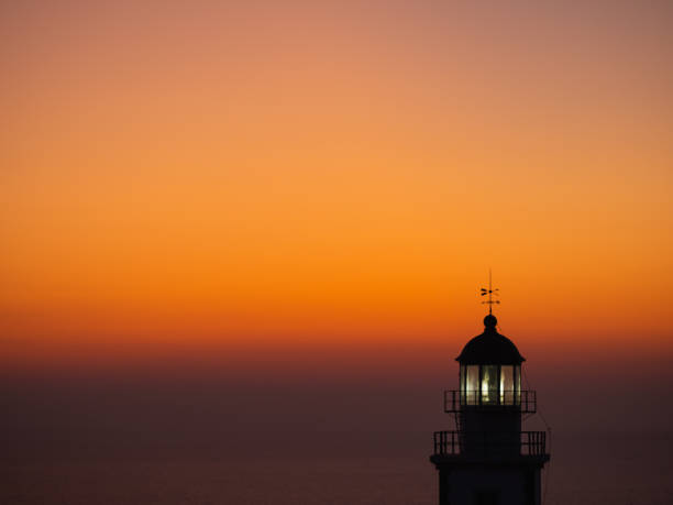 istock seascape with silhouette of a lighthouse at sunset 1312254832