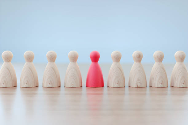 istock Success And Leadership Concept - Pawns Sitting In A Row On Wood Surface Before Defocused Grey Background 1312255155