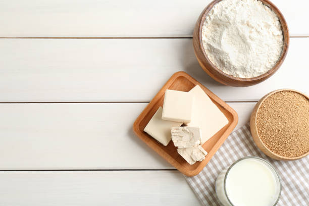 istock Yeast and dough ingredients on white wooden table, flat lay. Space for text 1312256721