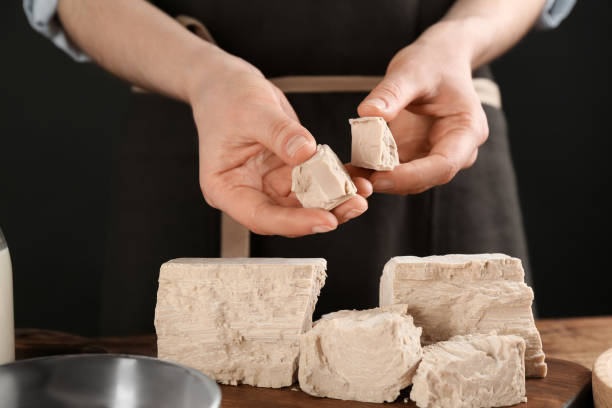 mujer con trozos de levadura comprimida en mesa de madera, primer plano - bakers yeast fotografías e imágenes de stock