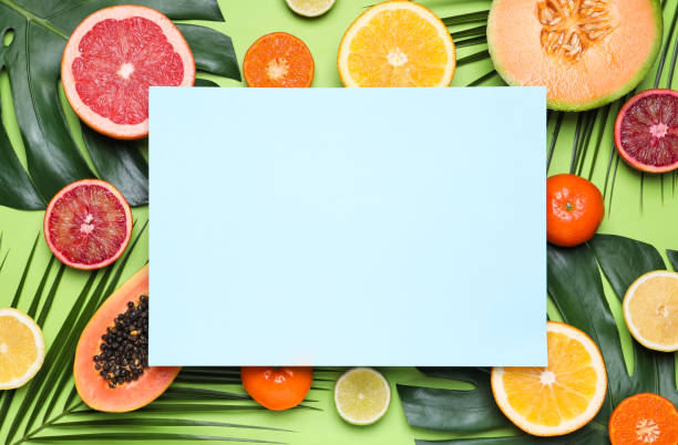 istock Different exotic fruits and blank card on green background, flat lay. Space for text 1312256942