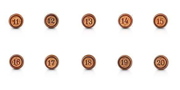the numbers from eleven to twenty carved in round pieces of wood are isolated on a white background with shadow and reflection