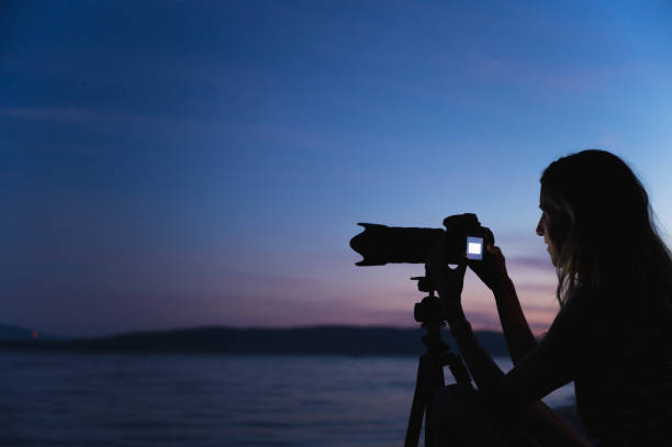 istock Young female photographer setting up her camera 1312257918