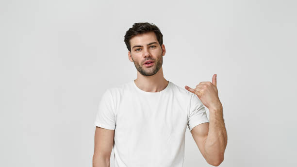istock Man in t-shirt doing cool symbol with hand up 1312258388