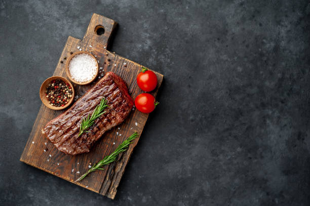 istock Grilled beef steak with spices on a stone background with copy space for your text. 1312258490