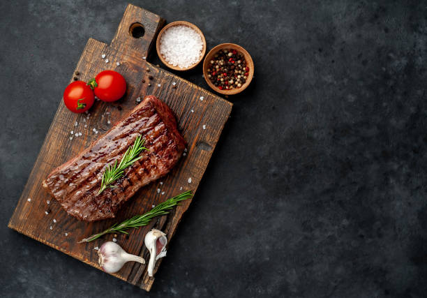 istock Grilled beef steak with spices on a stone background with copy space for your text. 1312258554