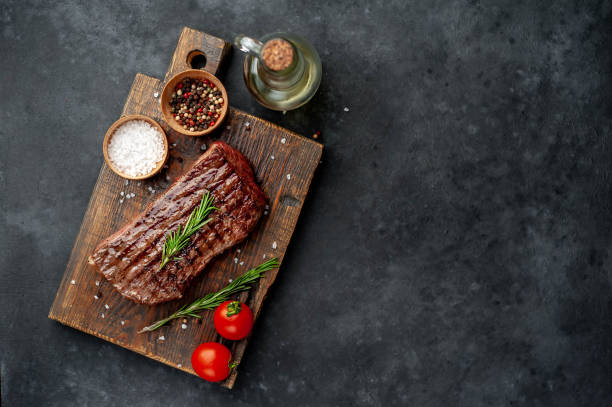 istock Grilled beef steak with spices on a stone background with copy space for your text. 1312258597