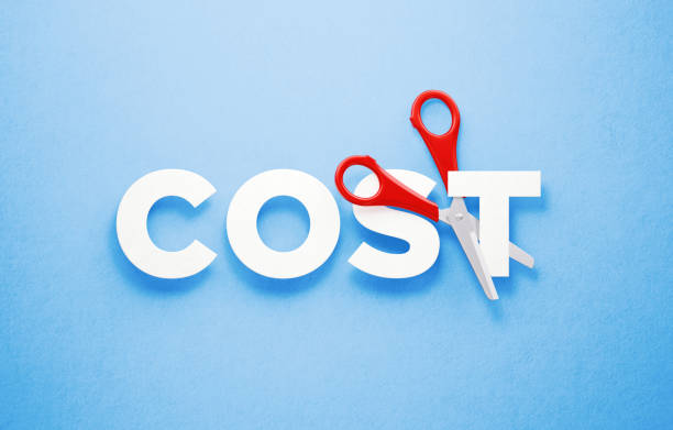 cutting costs concept - scissors cutting the word cost over blue background - cut price imagens e fotografias de stock