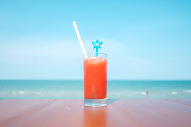 Fruit cocktail summer drink on vacation with blur beach on background