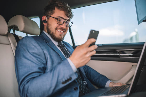istock A handsome entrepreneur using a smartphone while travel with car. 1312259538
