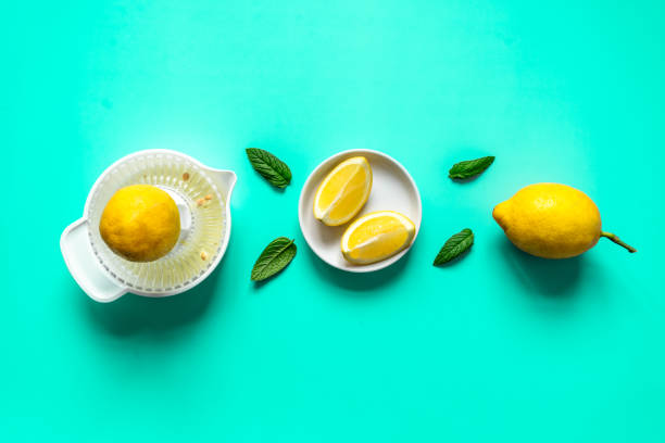 istock Lemons, lemon squeezer and peppermint leaves in a row on a mint background 1312259592
