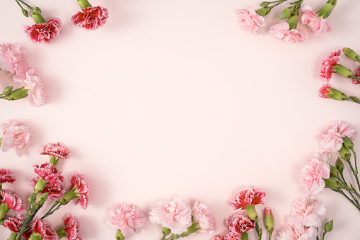 Concepto de diseño del saludo navideño del Día de la Madre con ramo de claveles sobre fondo de mesa rosa photo