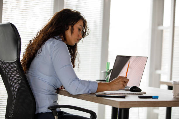 istock Diligent young businesswoman writing down notes while working at her desk 1312260278