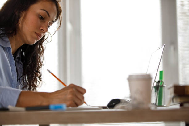 istock Copy space of businesswoman taking notes while working at her desk 1312260426