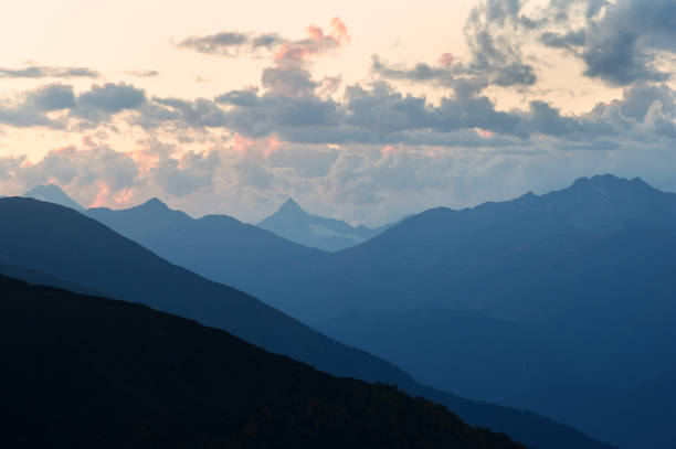 istock Mountain silhouettes and clouds highlighted by the sun 1312260473
