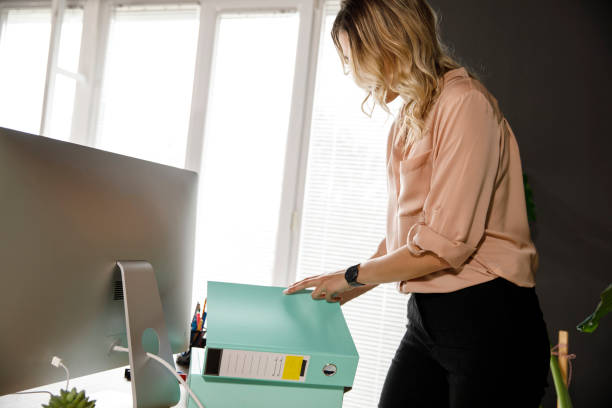 istock Businesswoman checking file binders with important project paperwork 1312261425