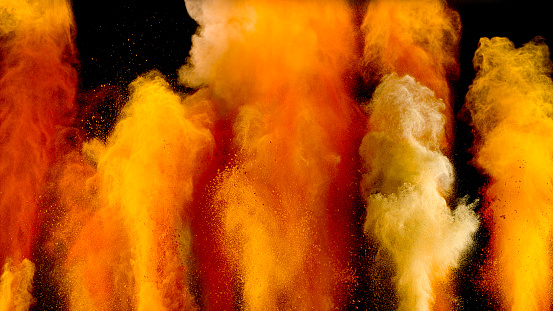 Explosion of different spices in air against black background.