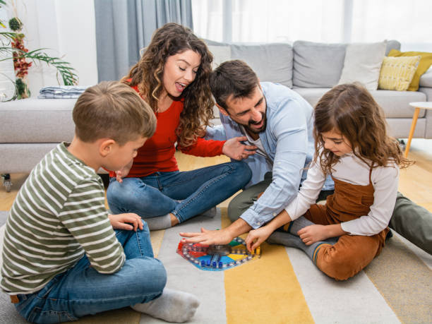 istock Cheerful parents playing board game with their children. 1312264136