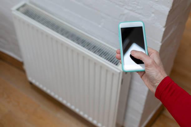 casa eficiente em energia - thermostat dial human hand white - fotografias e filmes do acervo