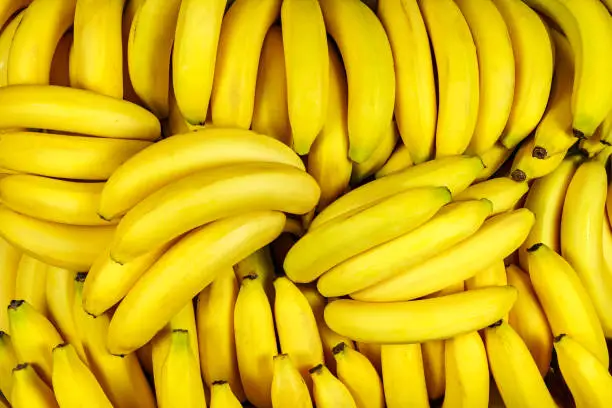 Photo of Background of many banana pieces, overhead view, studio food photography.