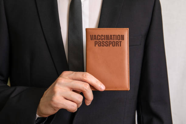 Vaccination Passport. Businessman showing passport covers Vaccination Passport. Businessman showing passport covers. medical exams for visa appliaction stock pictures, royalty-free photos & images